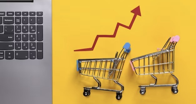 Laptop, shopping carts with growth arrow on yellow background