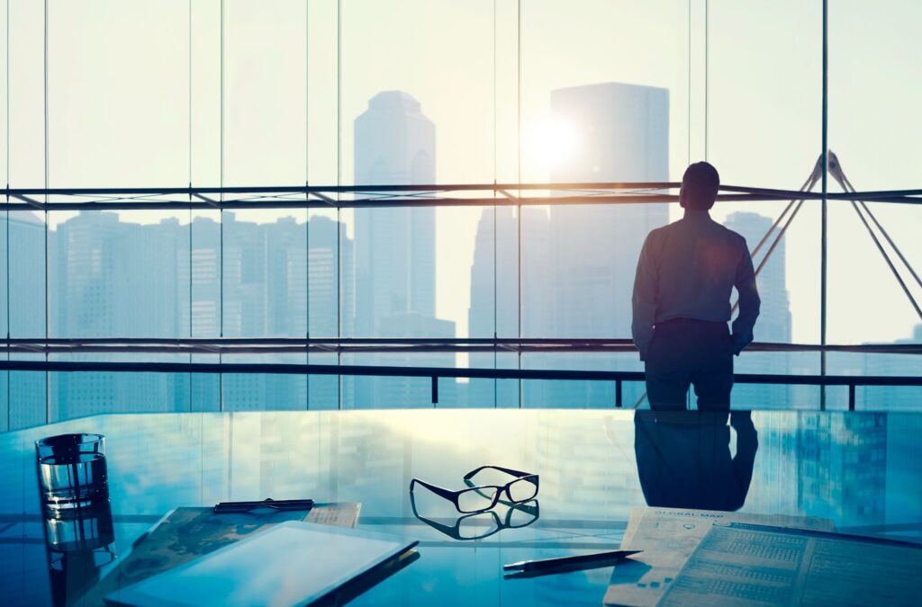 businessman in a big office looking in window