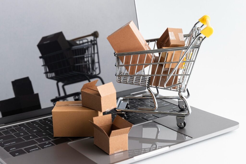 Miniature shopping cart placed on the keyboard, filled with boxes