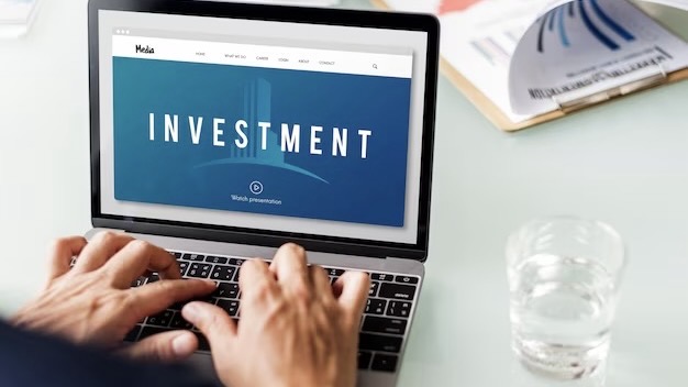 Hands on laptop keyboard with investment inscription